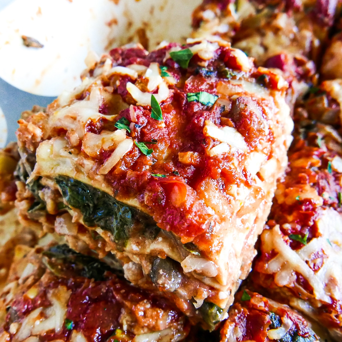 slice of no boil lasagna being lifted from baking dish.