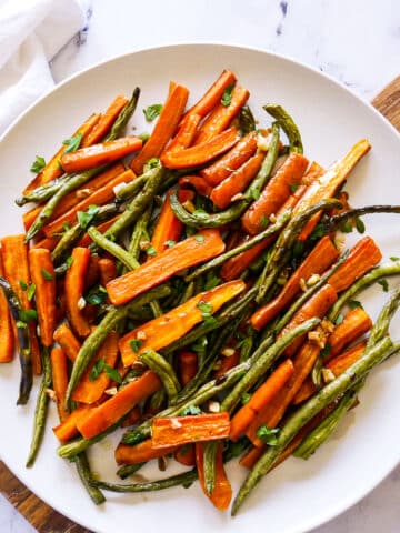 Platter of roasted carrots and green beans drizzled with balsamic.