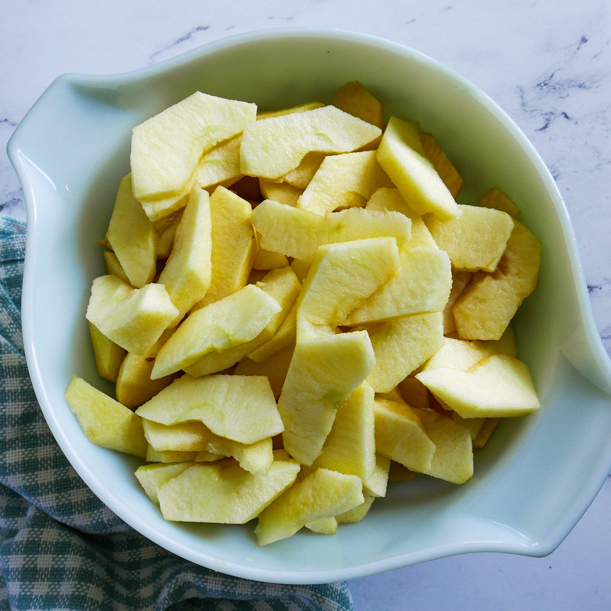 peeled, cored, and sliced apples in a large bowl.