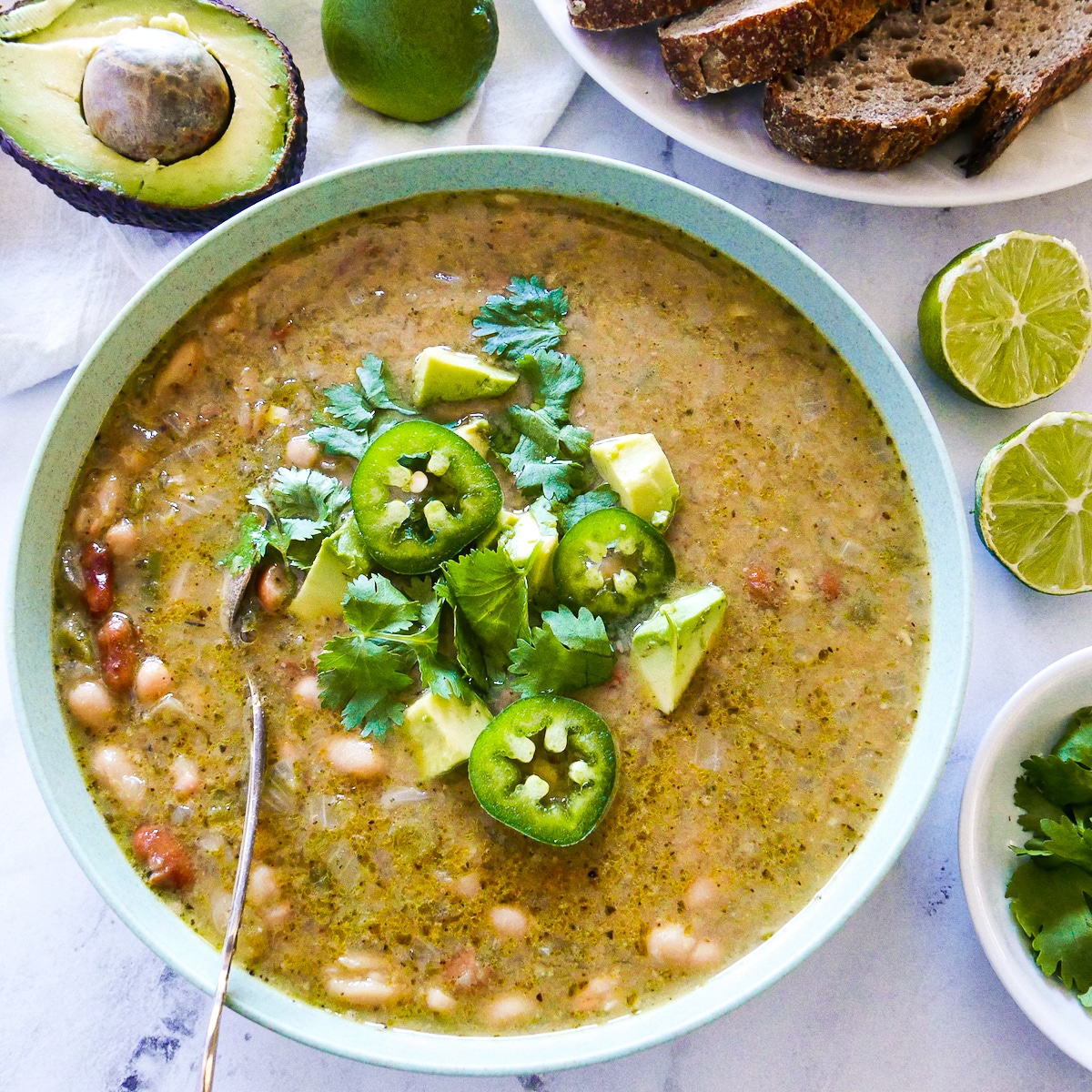 bowl-of-soup-and-plate-of-bread.jpg bowl of chili with plate of bread in the background.