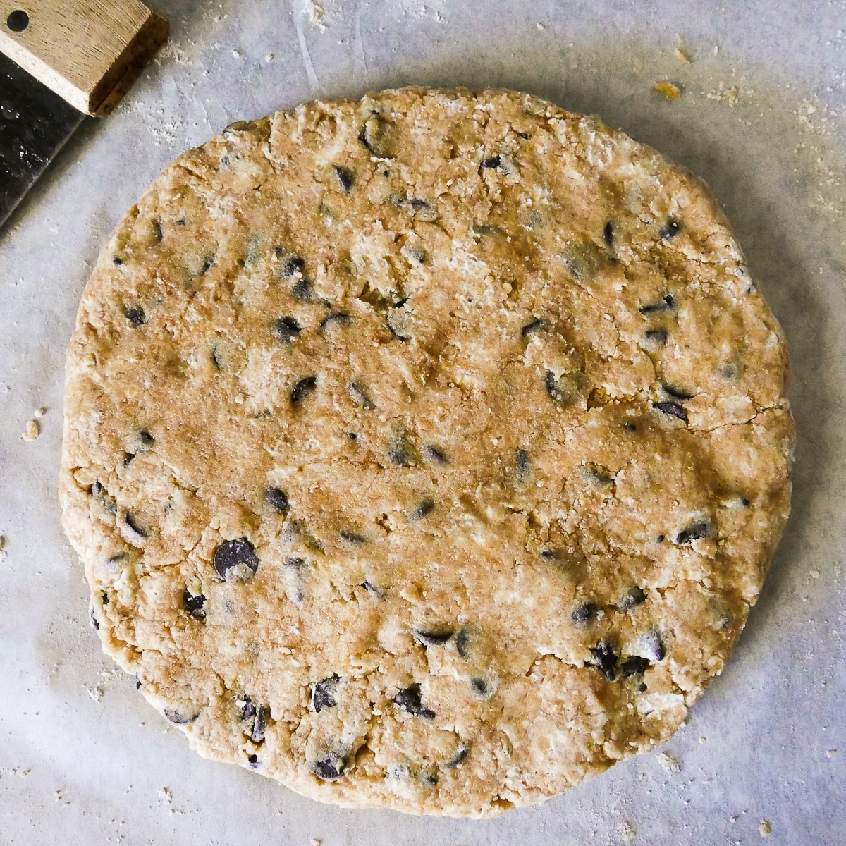 scone dough shaped into a disc on parchment paper.