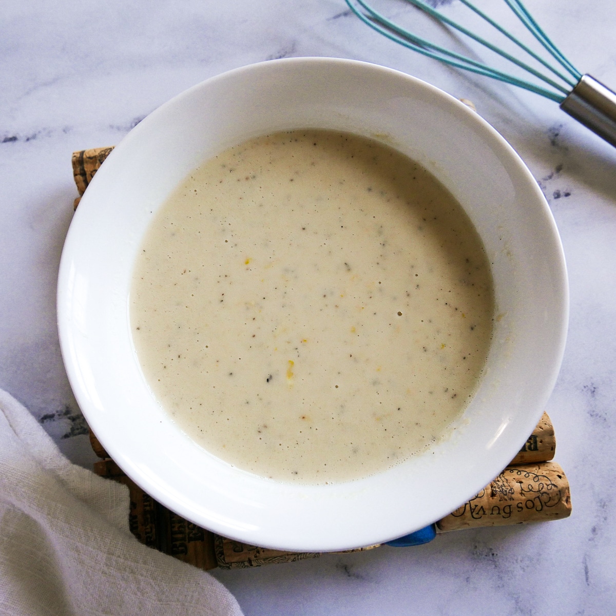 small bowl of tahini pasta sauce with a whisk.