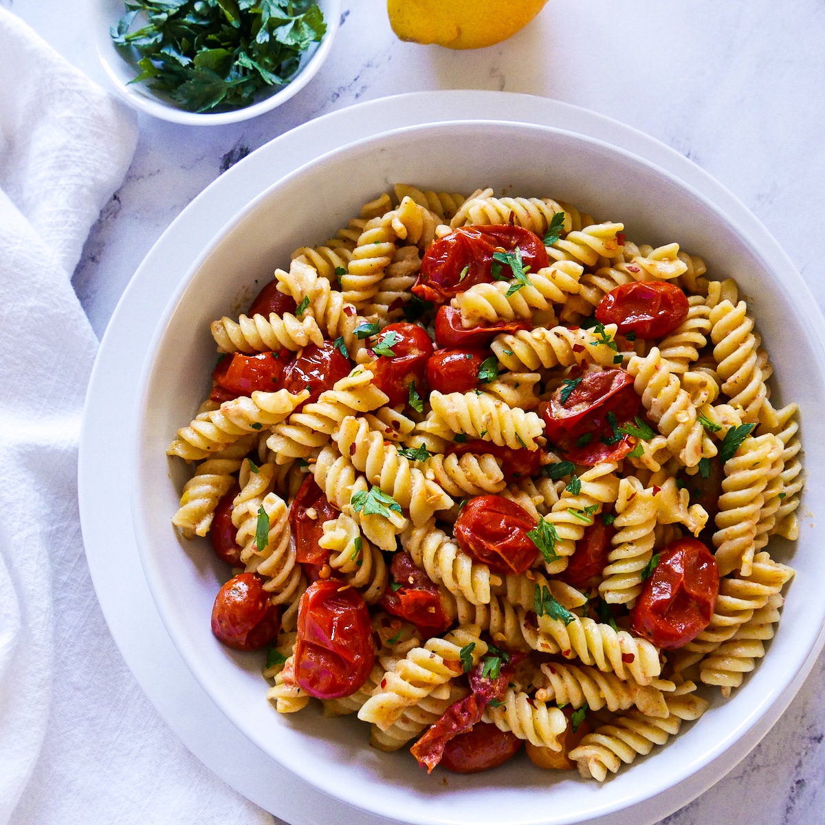 bowl of pasta with tahini and fresh parsley.