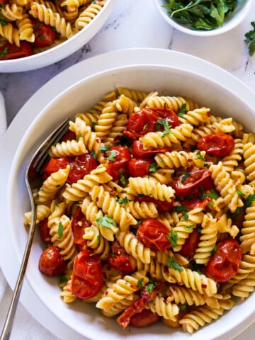 bowl of creamy tahini pasta with a fork and white napkin.