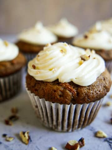 carrot cake cupcakes arranged on a table.