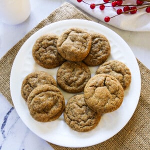 plate of ginger snaps with red holly in the background.