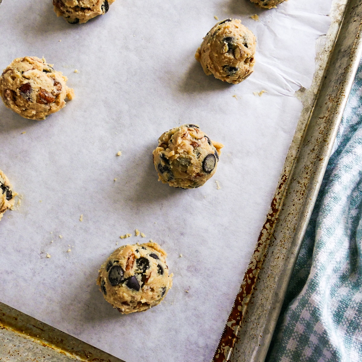 cookie dough scopped onto a parchment lined baking sheet.