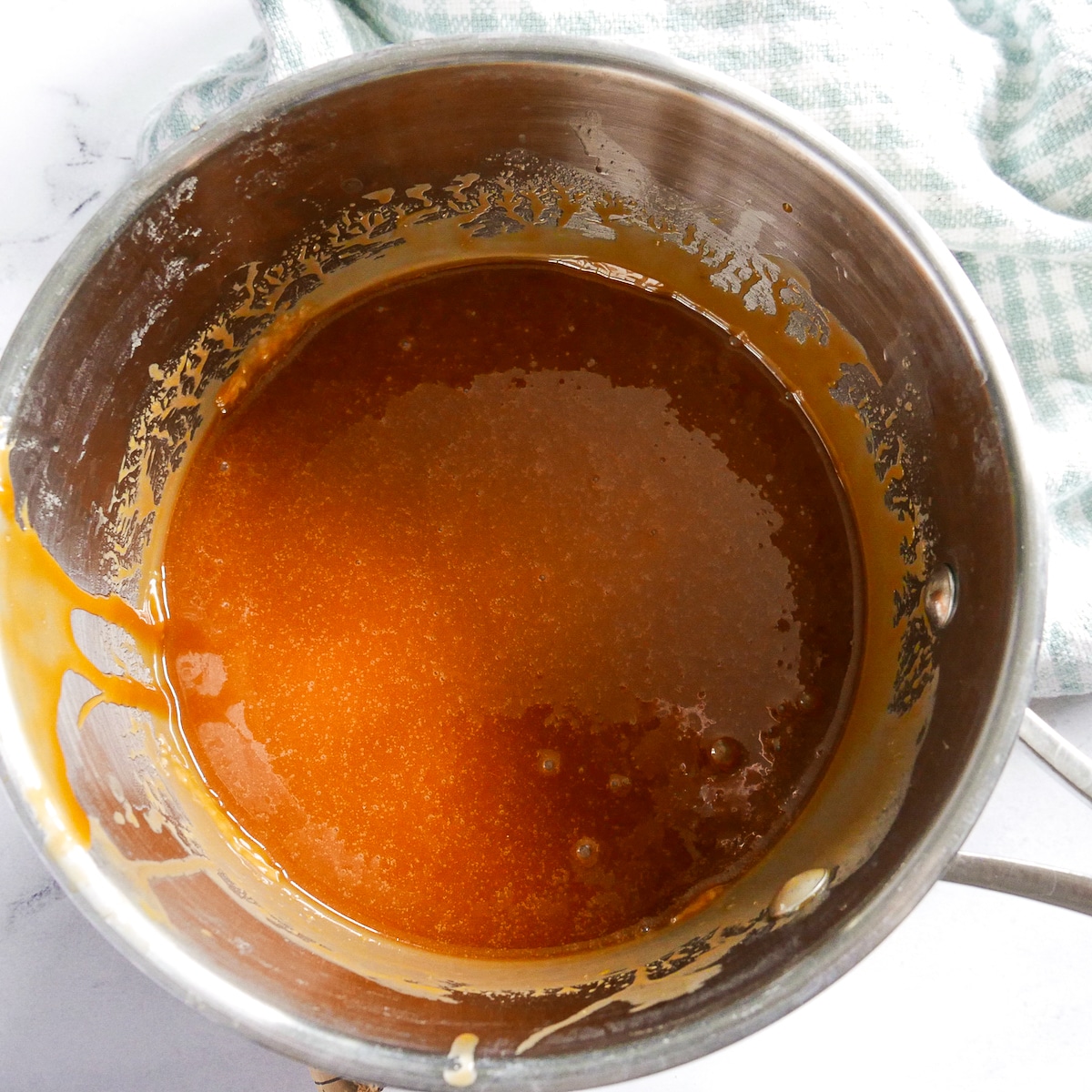 salt and vanilla added to caramel sauce in a sauce pan.