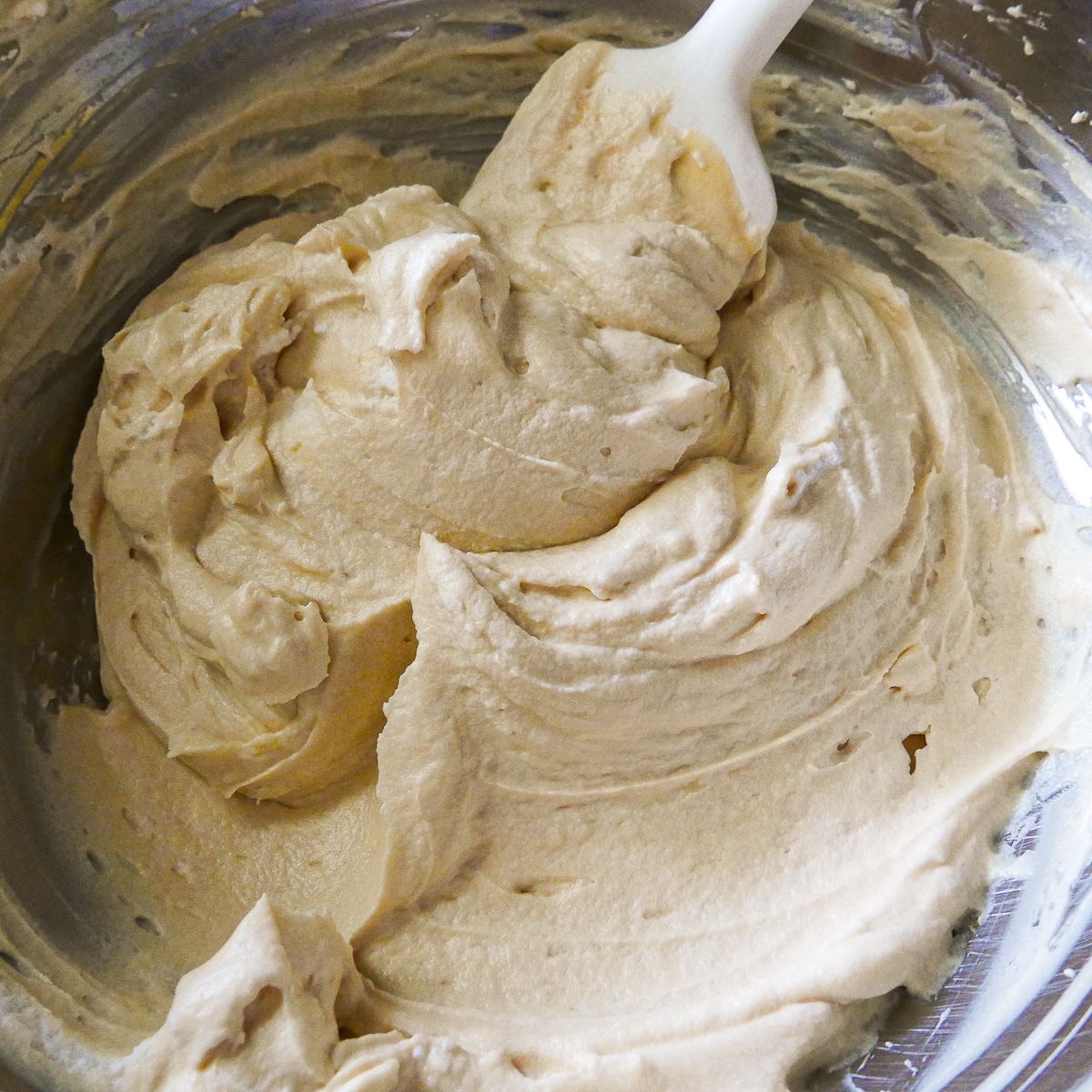 whipped cream being folded into caramel cheesecake mixture.