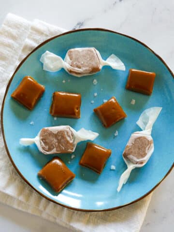 homemade salted caramels arranged on a blue plate.