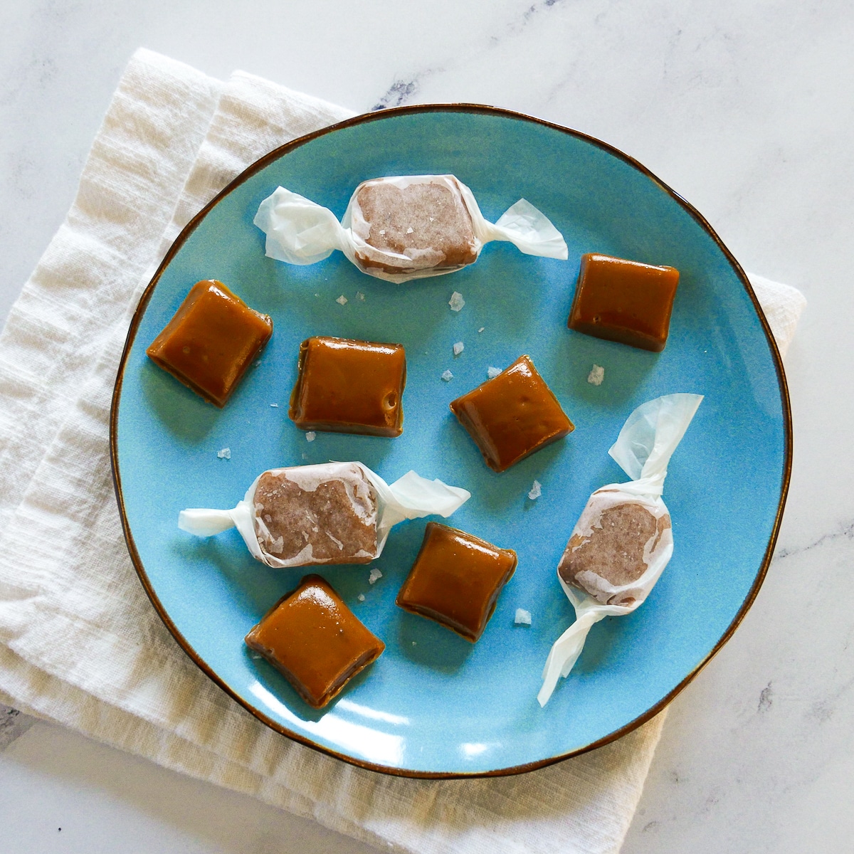 homemade salted caramels arranged on a blue plate.