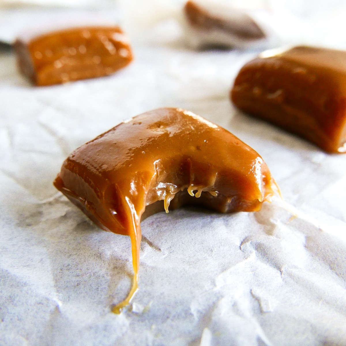 caramel with a bite missing on parchment.