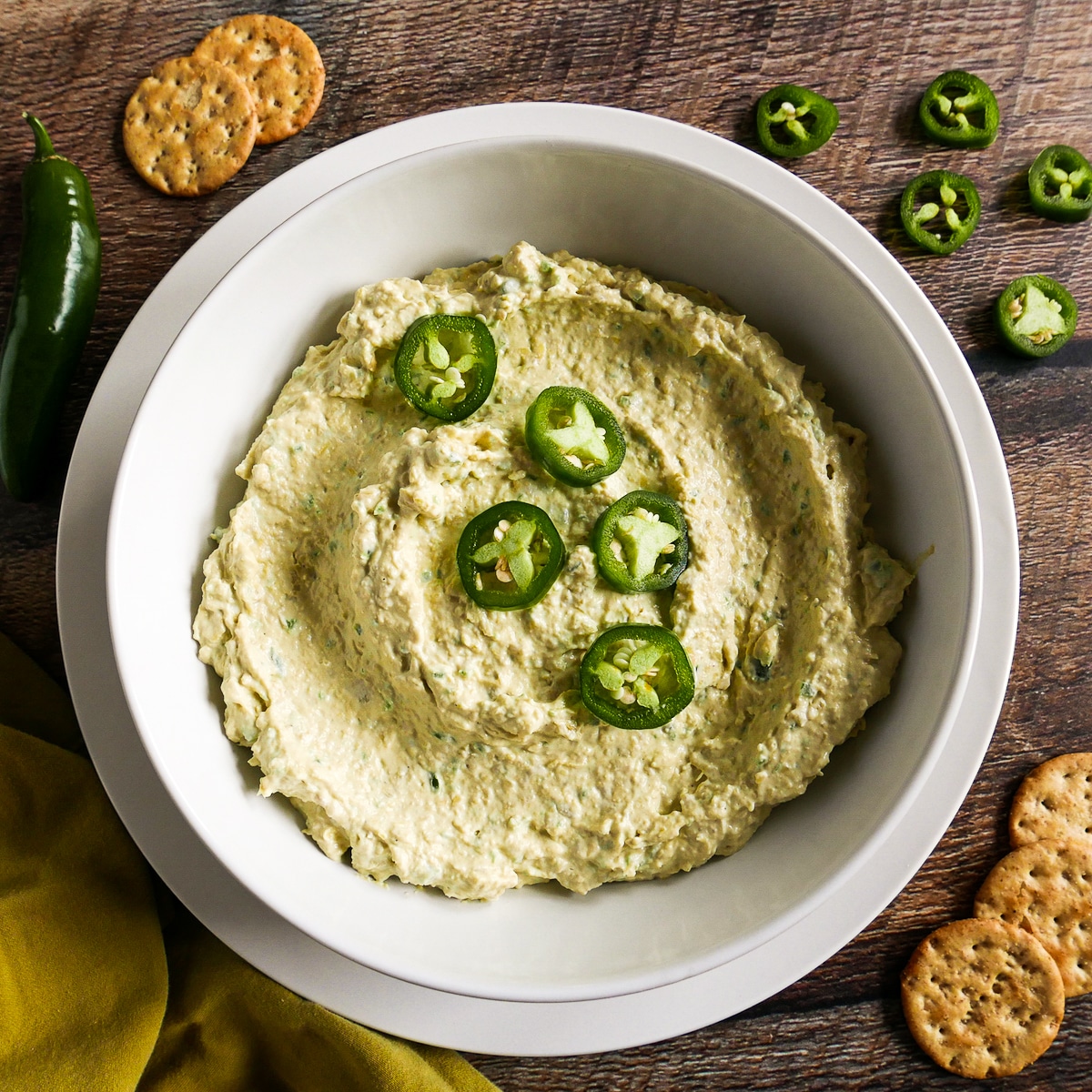 bowl of jalapeno dip garnished with sliced jalapenos.