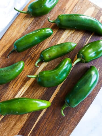 jalapeno peppers arranged on a cutting board.