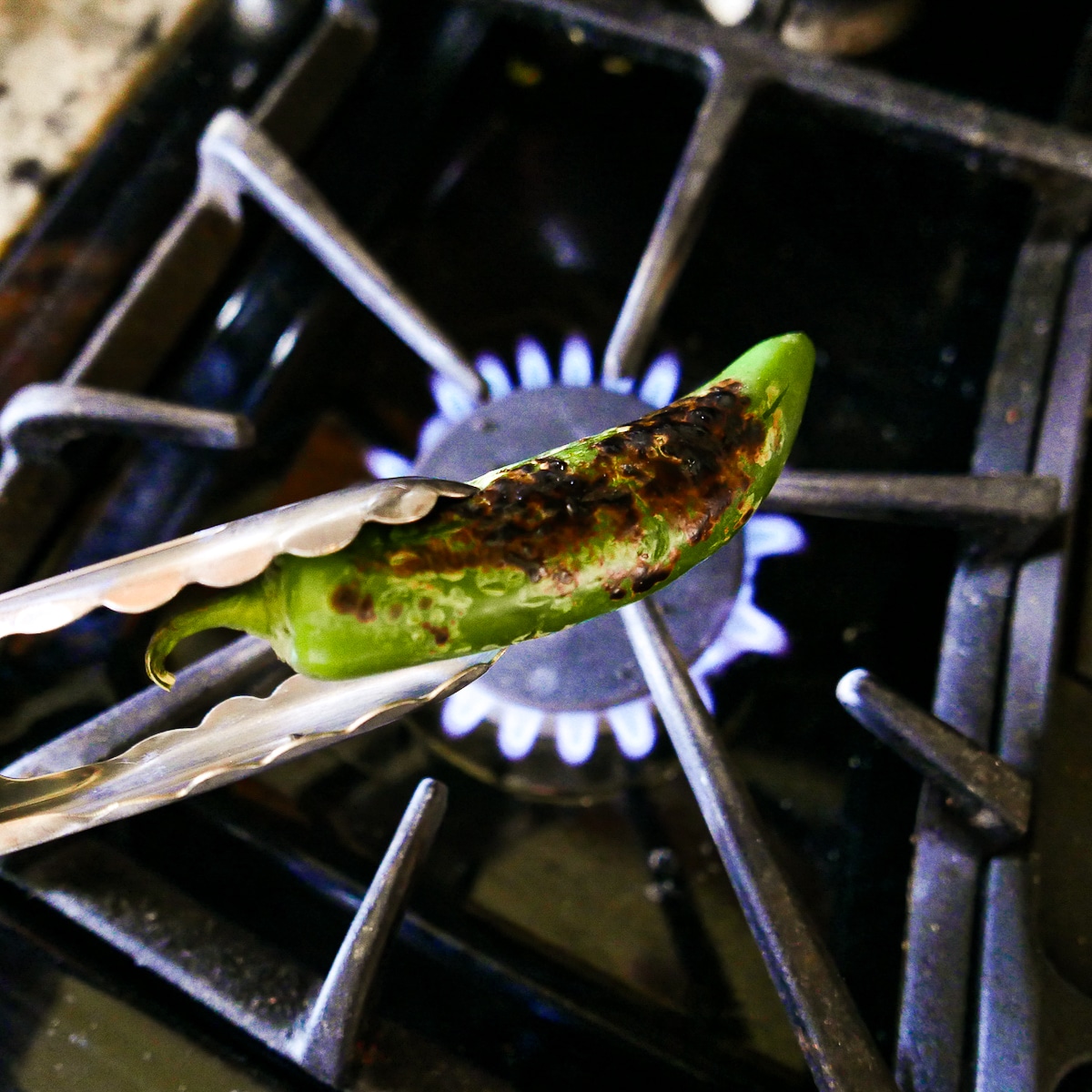 charred jalapeno over an open flame. 