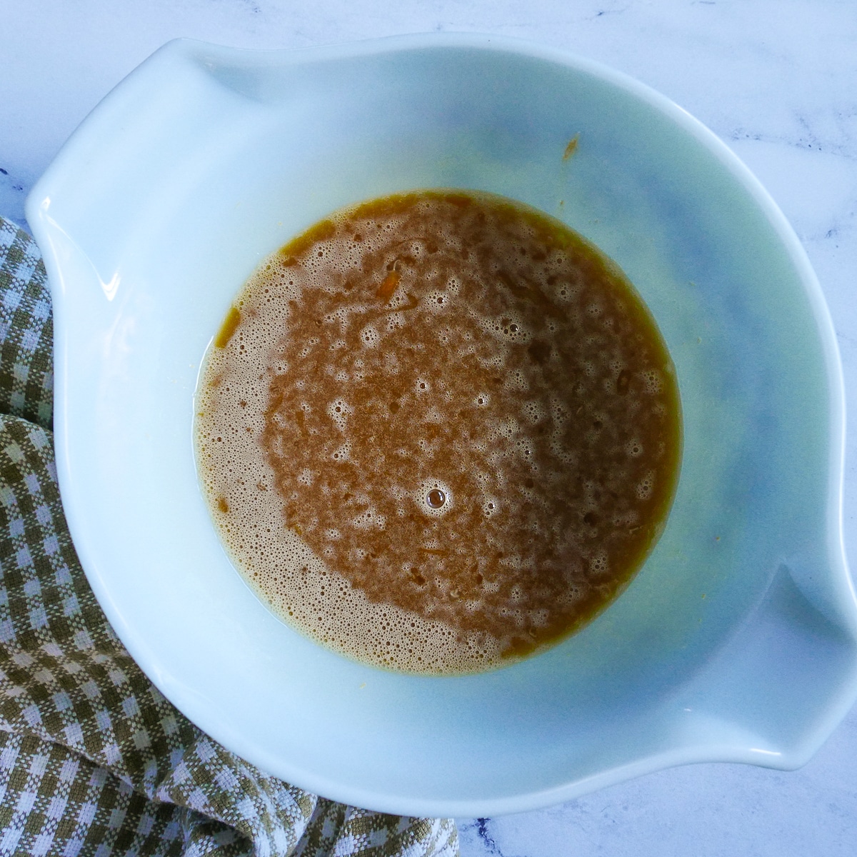 butterscotch mixture added to egg mixture in a mixing bowl.