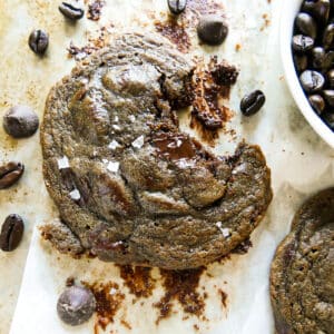 chocolate coffee cookie on parchment paper with a bite missing.