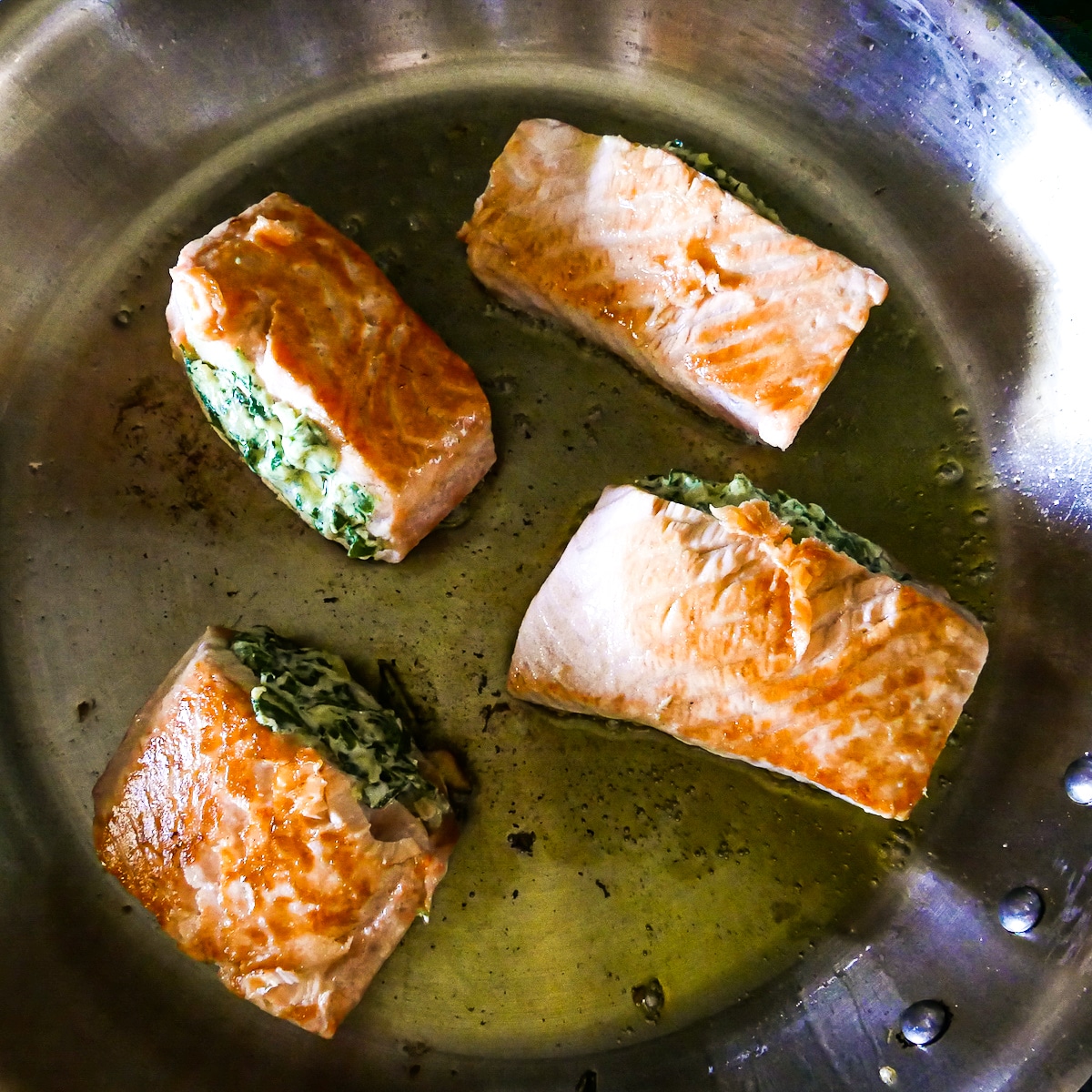 golden and crispy salmon cooking in frying pan.