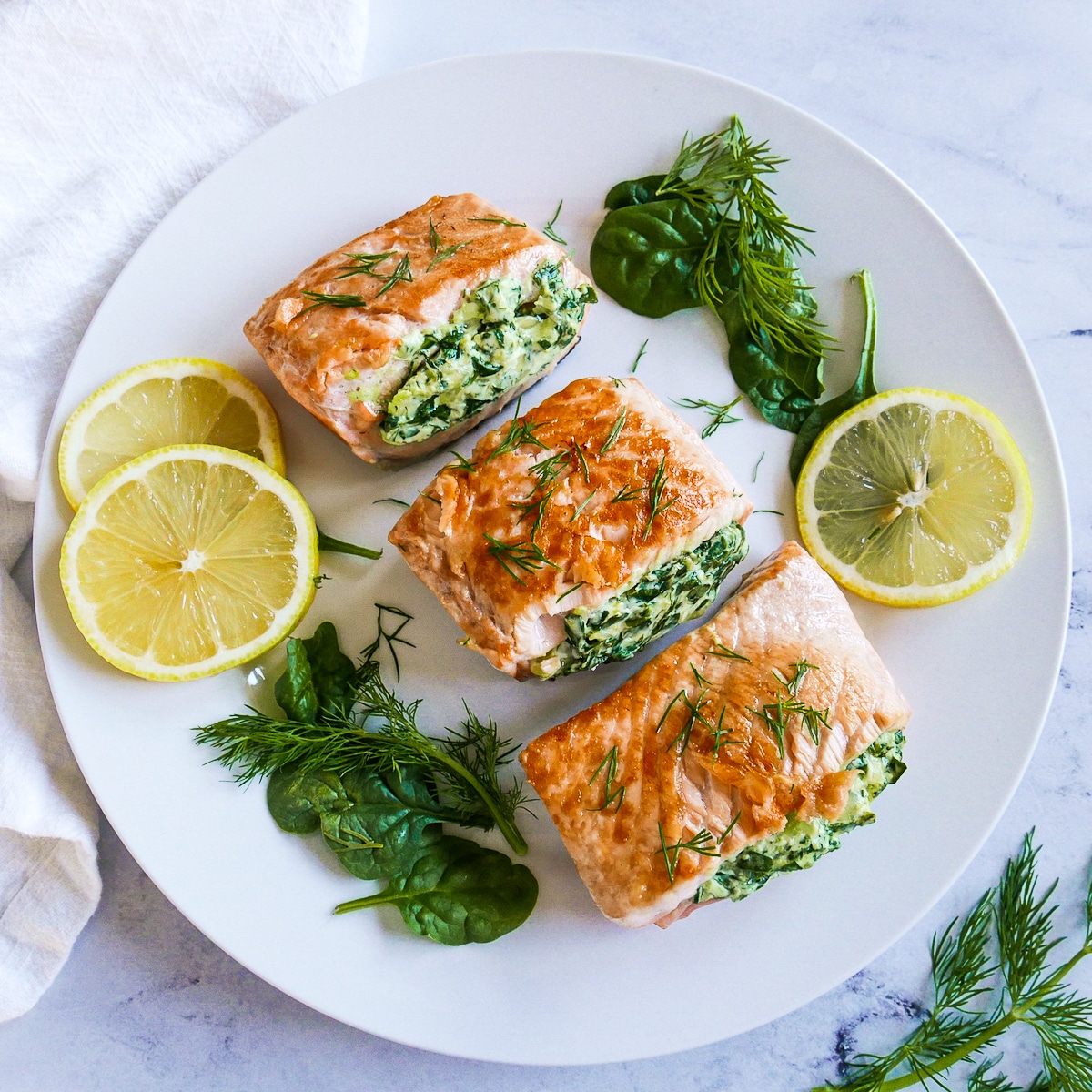 stuffed spinach with salmon on a white platter.