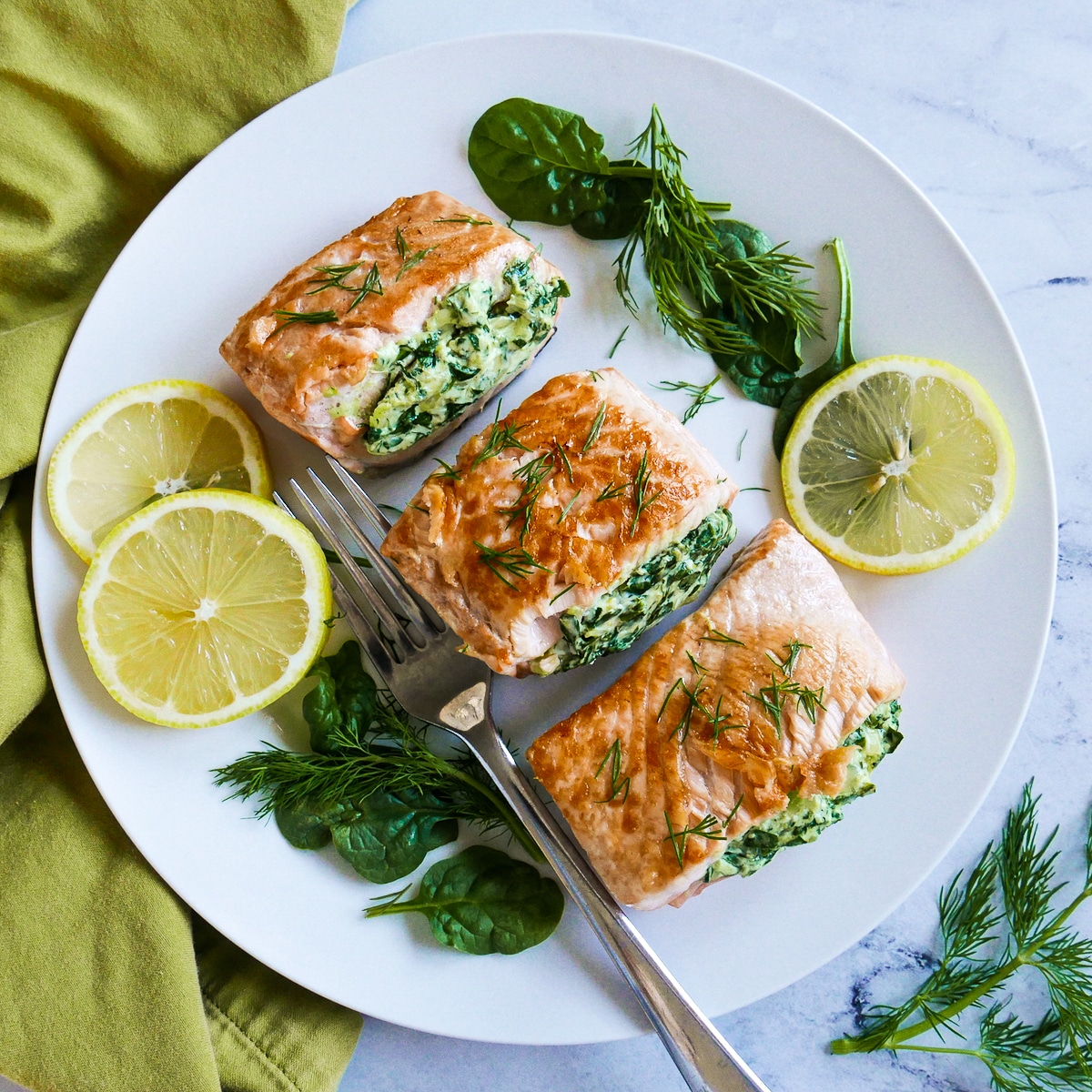 three-pieces-of-salmon.jpg plate of three pieces of salmon with a fork and lemon slices.