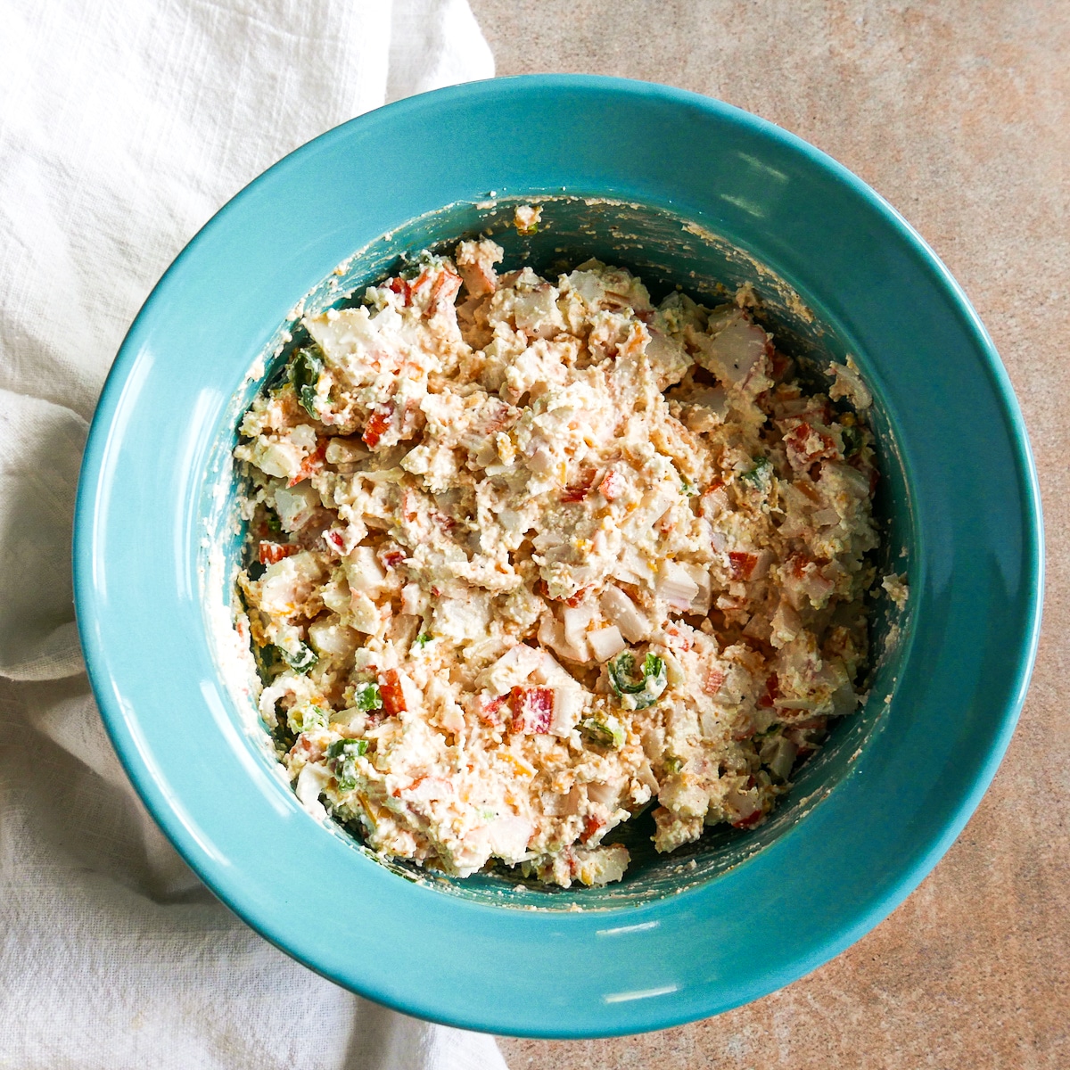 crab dip ingredients being combined in a medium bowl.