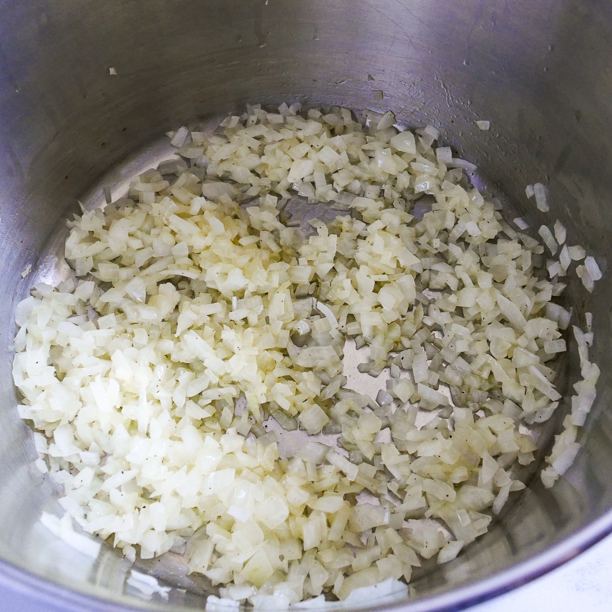 Chopped onion cooking in a large pot.