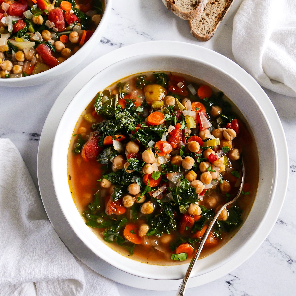 two bowls of soup with napkins and bread.