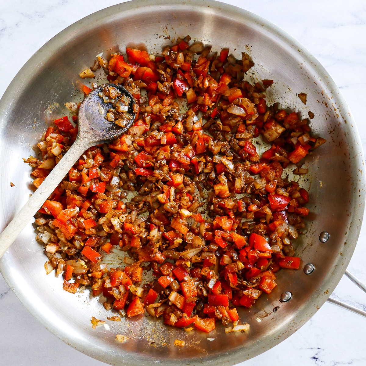 red pepper added to cooking mixture in pan.