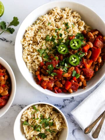 bowl of pinto beans and rice with two spoons and a napkin.