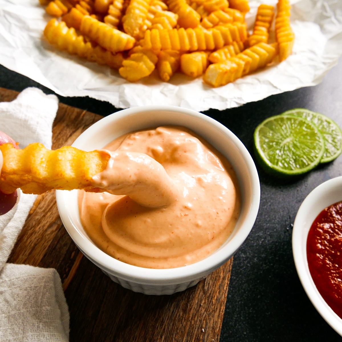 french-fry-dipped-into-mayo.jpg french fry being dipped into cup of spicy mayo.