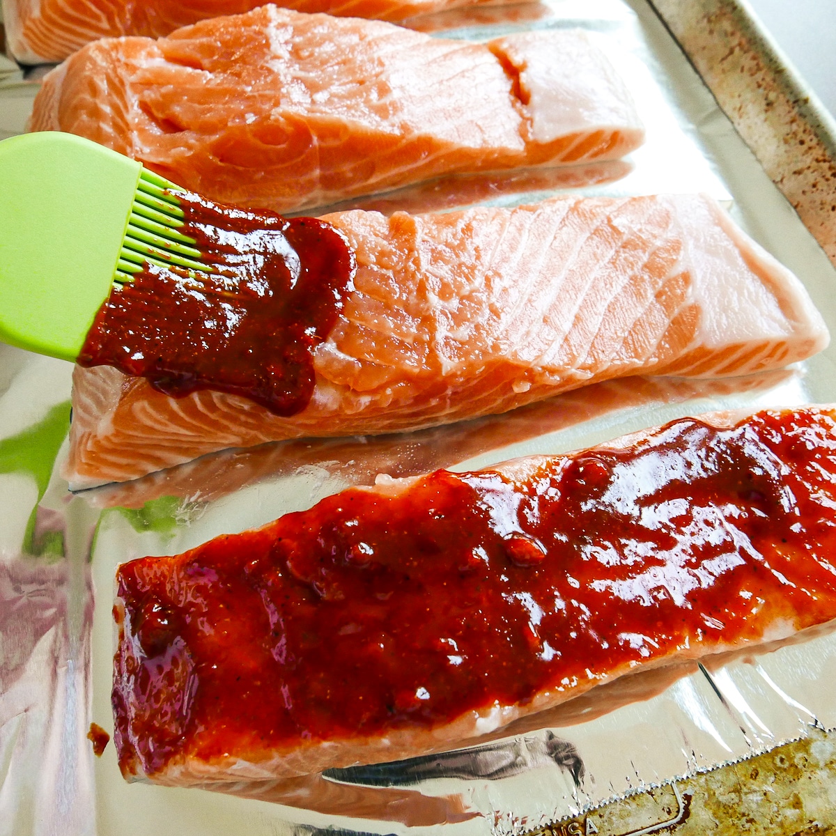 pastry brush spreading gochujang marinade onto salmon.