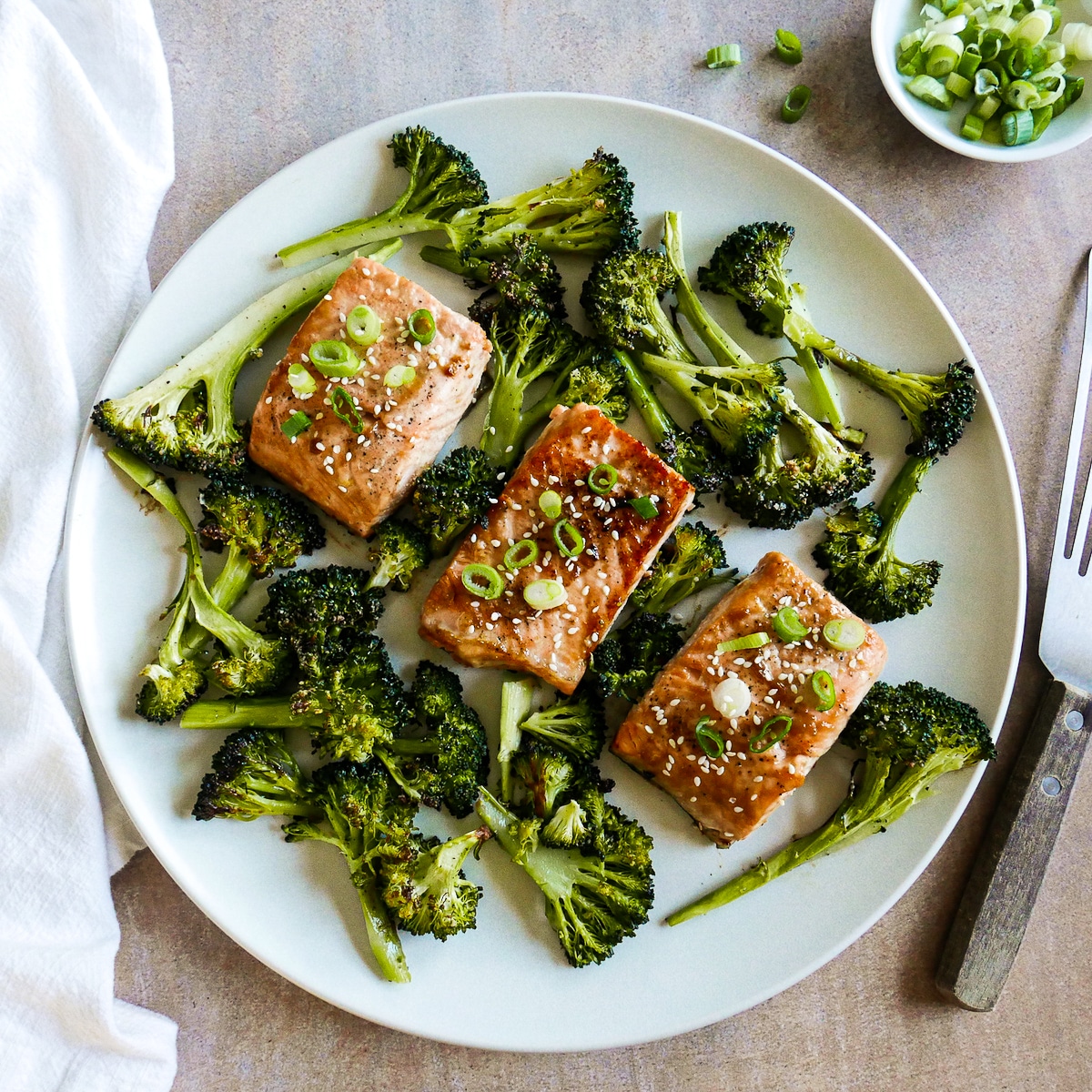 miso-salmon-on-platter.jpg three fillets of miso butter salmon on a white platter with roasted broccoli.