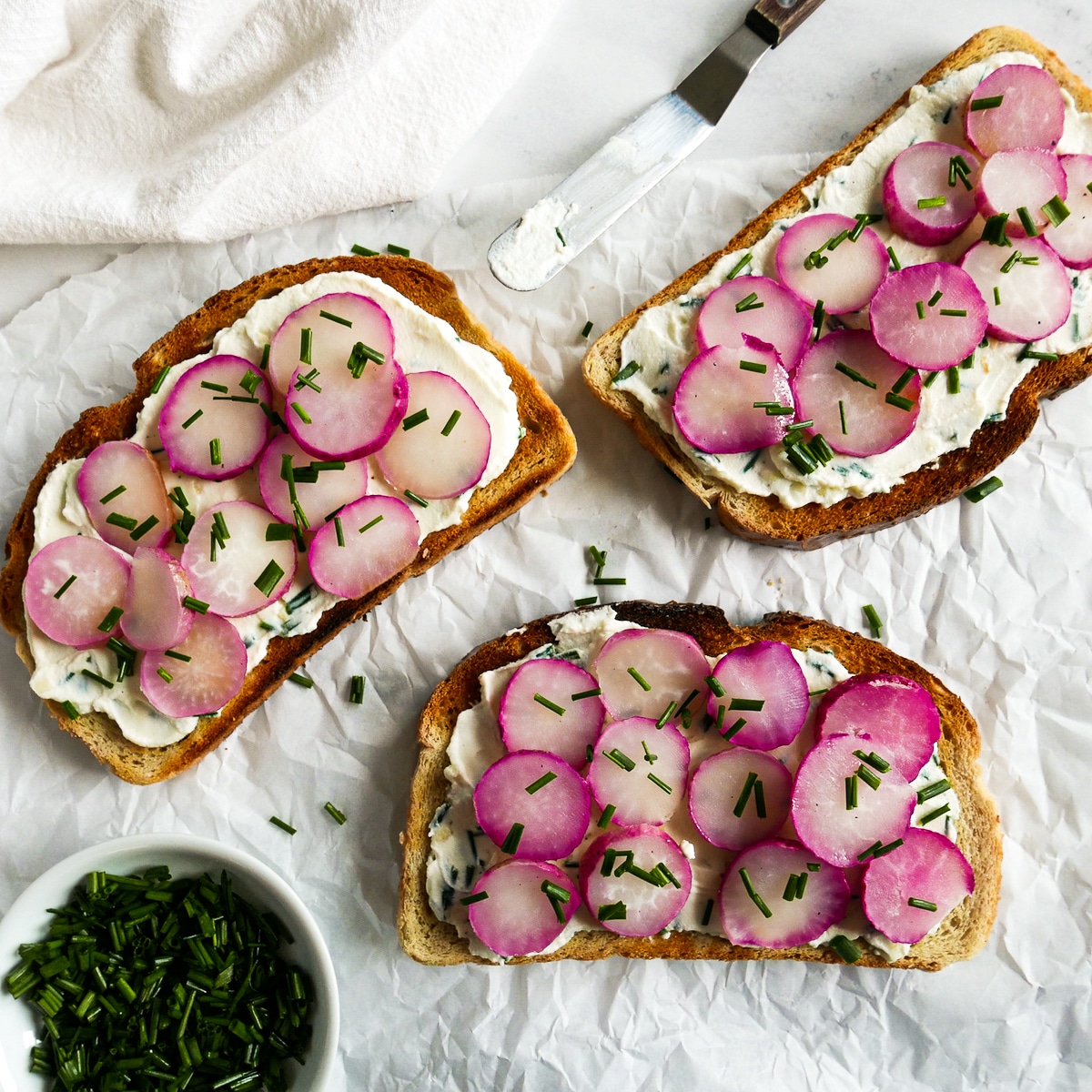 three pieces of seasoned radish toast on parchment paper.