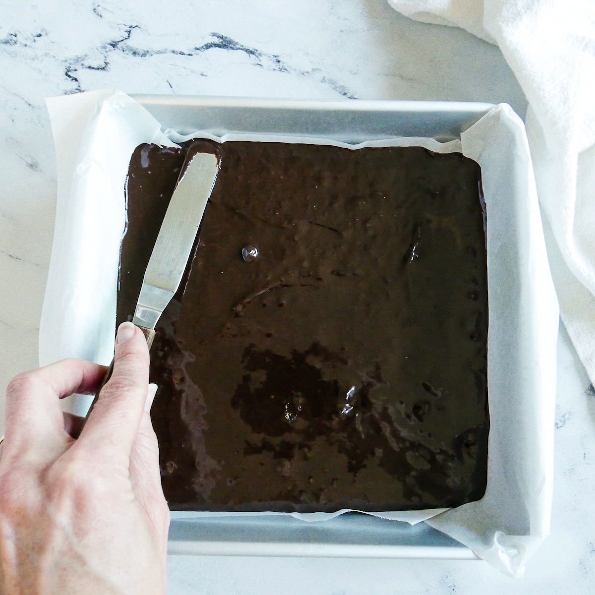 brownie batter poured into prepared metal pan.