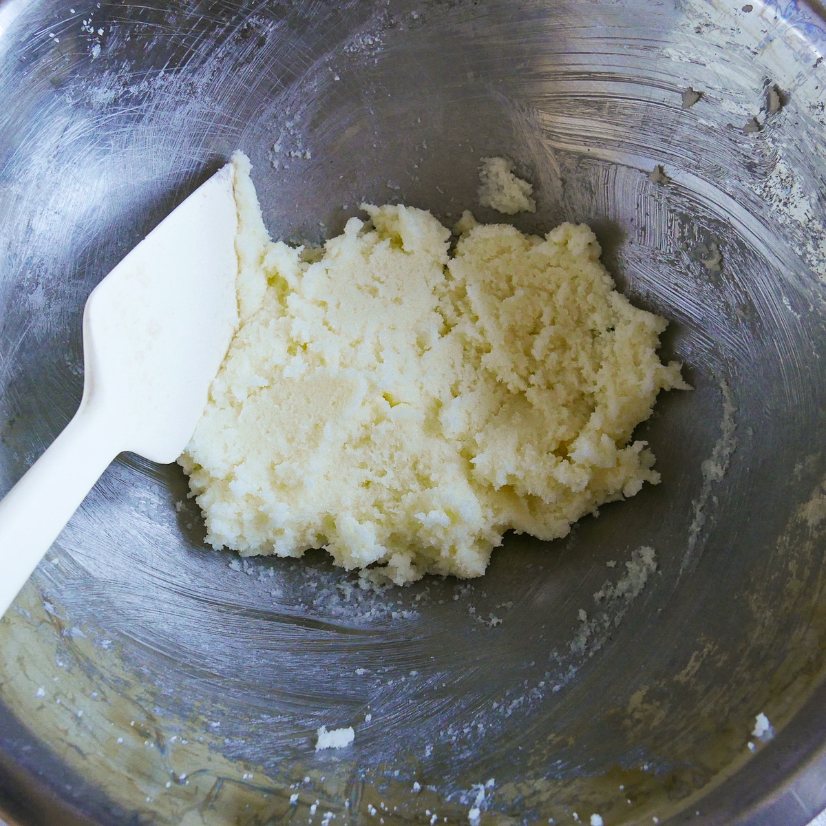 Butter and sugar creamed together in a medium bowl.