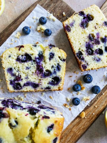 blueberry lemon pound cake sliced onto parchment paper.