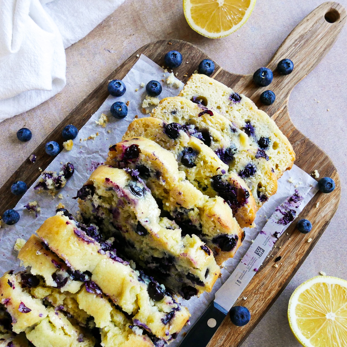 Ricotta pound cake sliced on a wooden cutting board with knife.