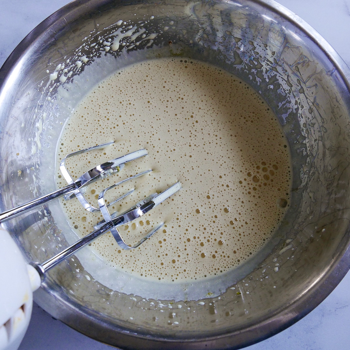 eggs and sugar mixed together with an electric hand held mixer.