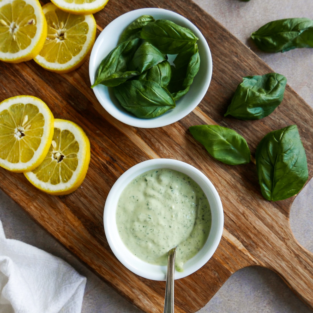 cutting board with basil, lemon, and garlic basil mayo.