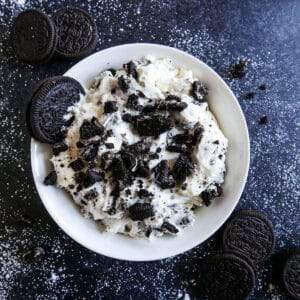 bowl of oreo cookie dip topped with crushed oreos.
