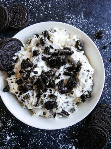 bowl of oreo cookie dip topped with crushed oreos.