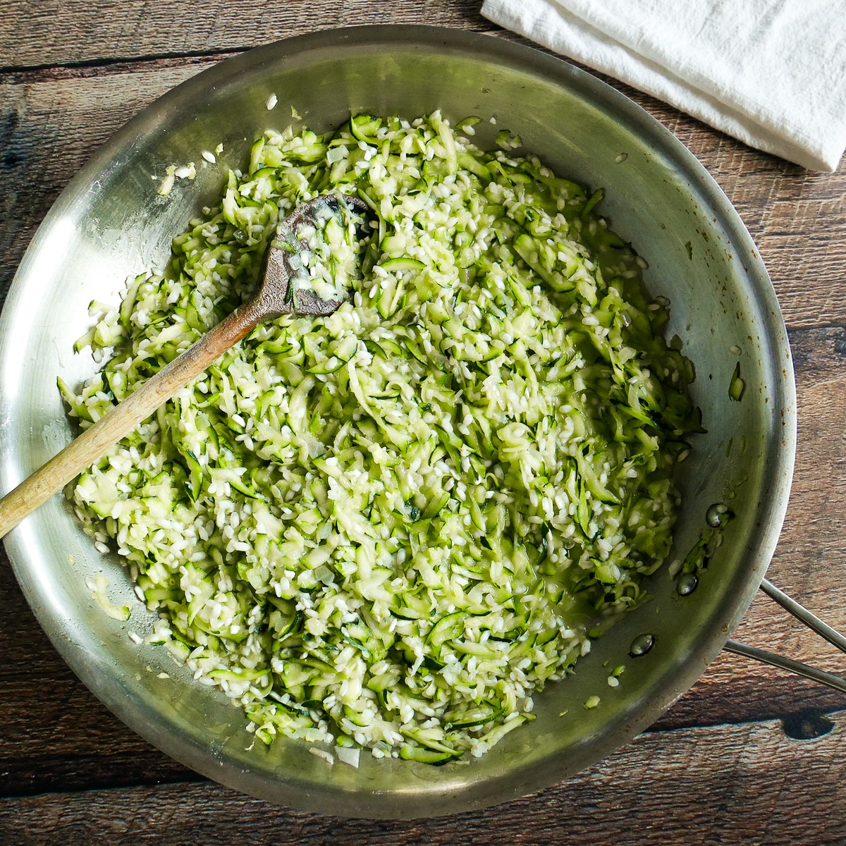 Arborio rice added to large skillet with zucchini.