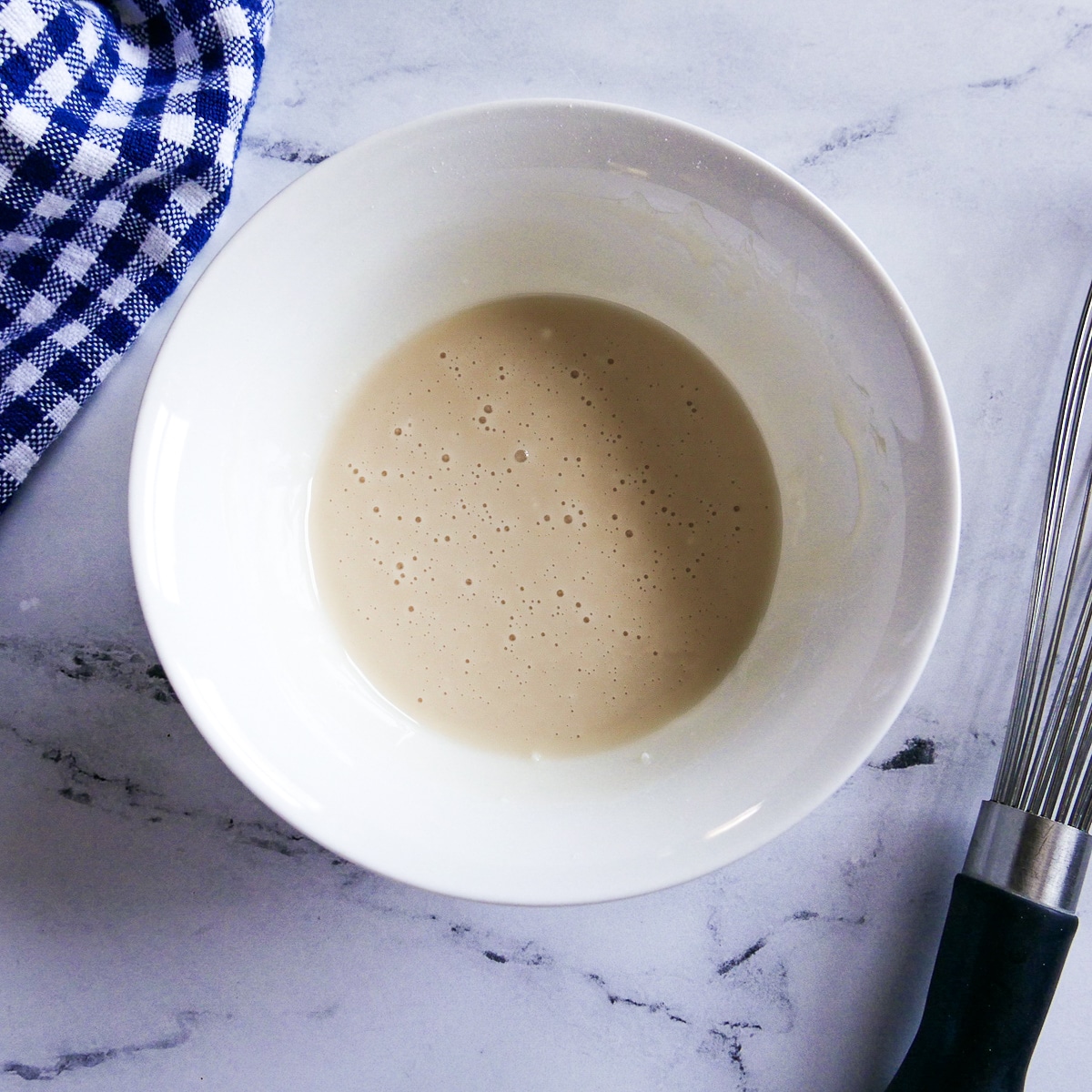 Vanilla glaze mixed together in a small white bowl.