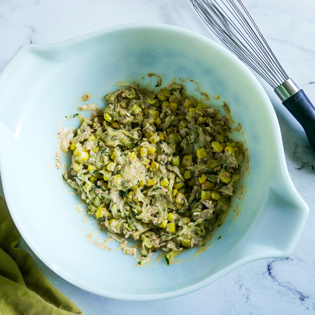 Fritter batter whisked together in a medium bowl.