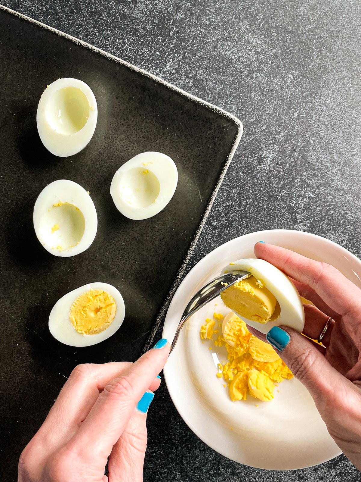 scooping-yolk-from-egg.jpg teaspoon scooping the yolk from a hard boiled egg.