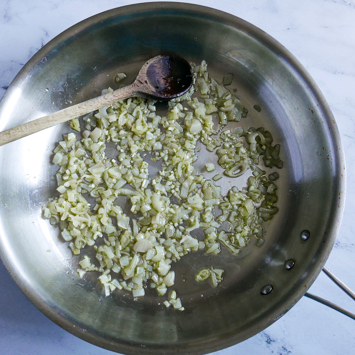 Shallots and garlic cooking in a large skillet.