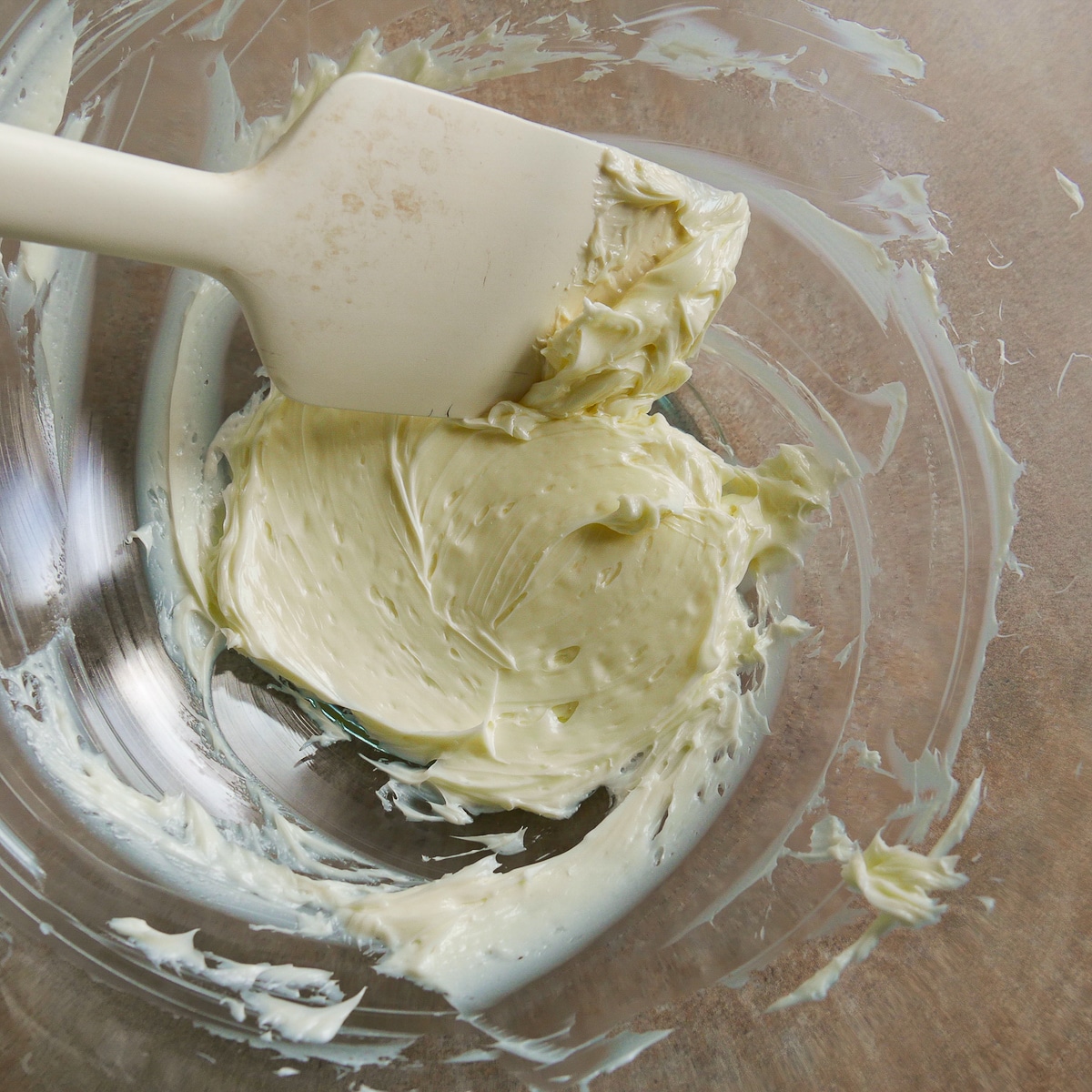 Beaten butter in a mixing bowl.