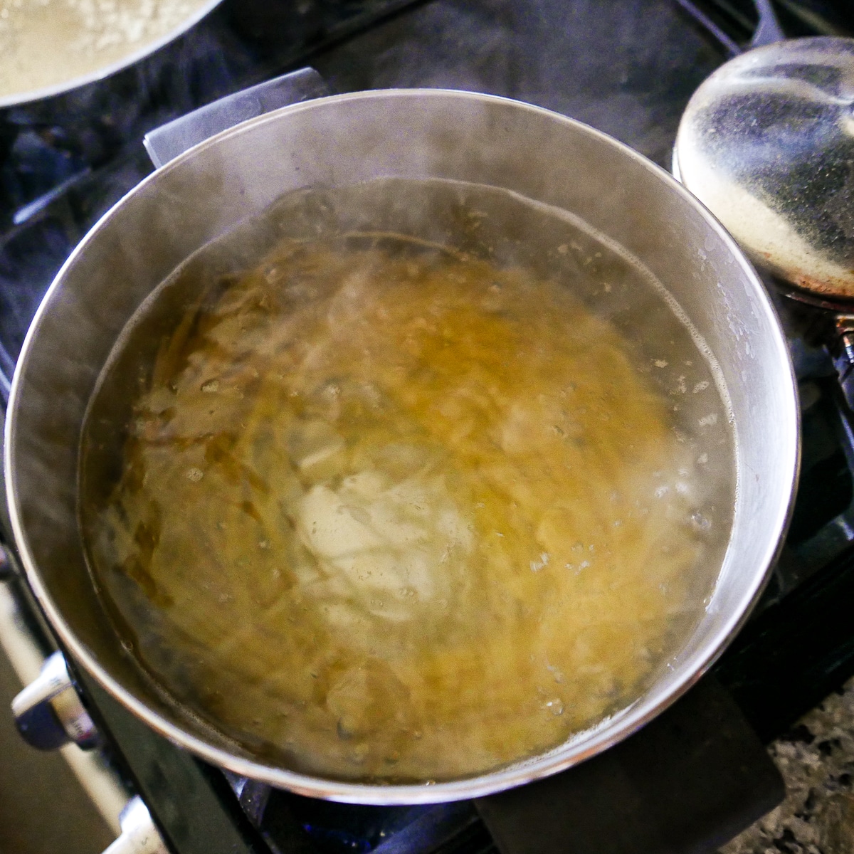 Linguine noodles cooking in a large pot.