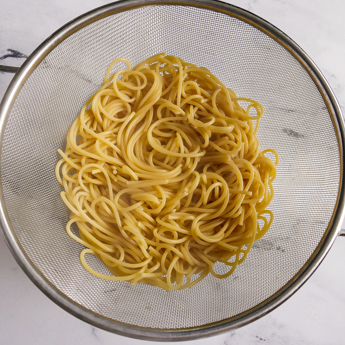 Drained noodles in a colander.