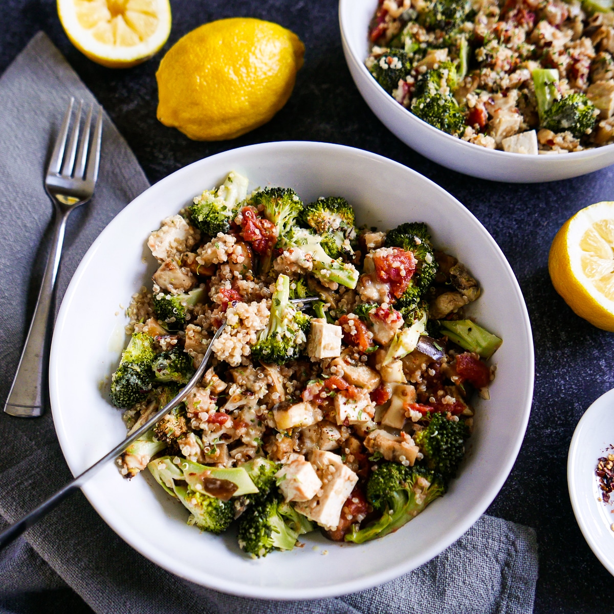 Fork resting in a quinoa bowl with roasted vegetables and tofu.